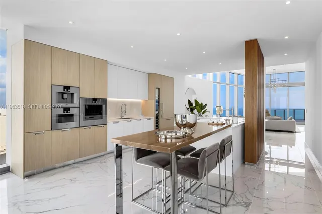 a kitchen with stainless steel appliances kitchen island granite countertop a refrigerator and cabinets