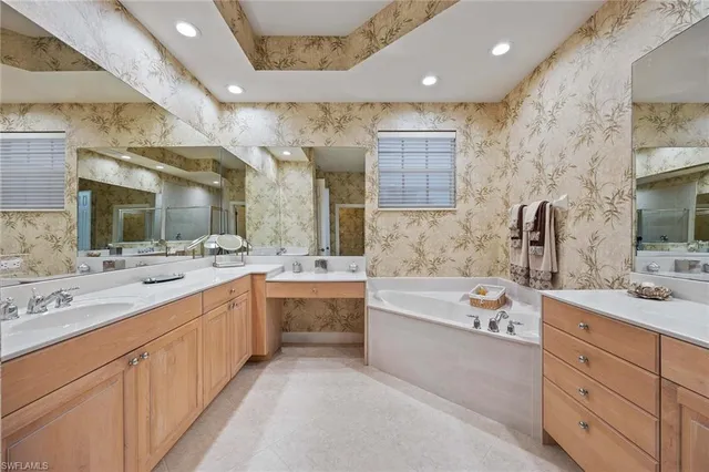 a large bathroom with a double vanity sink mirror and bathtub