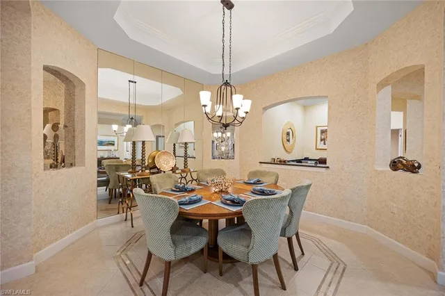 a dining room with furniture a chandelier and window