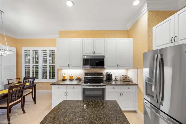 a kitchen with a refrigerator and a stove top oven