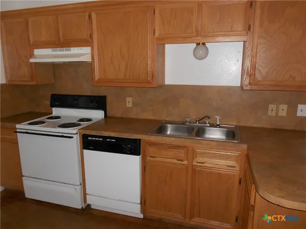 a kitchen with granite countertop cabinets stainless steel appliances and a sink