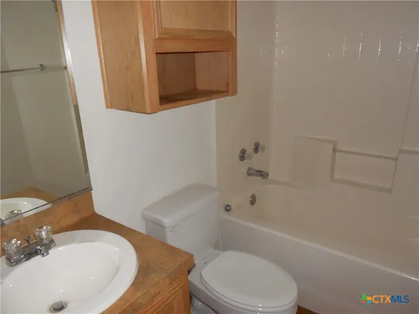 a bathroom with a sink and bathtub with toilet