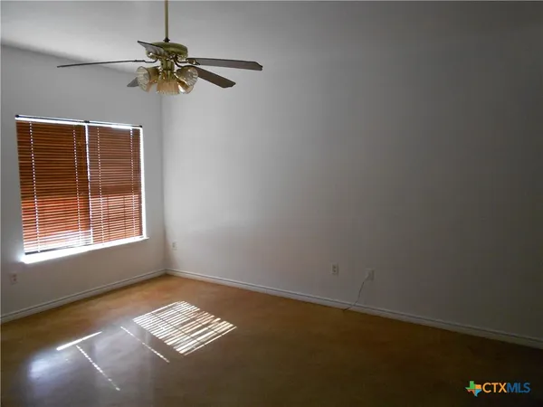 a view of room with a ceiling fan and window