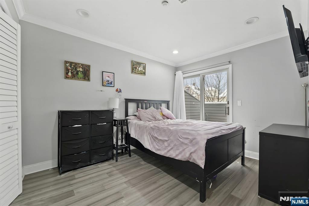 142 Main Avenue, Unit 4A Passaic, NJ 07055 - Photo 20 of 26 a bedroom with a bed and a television