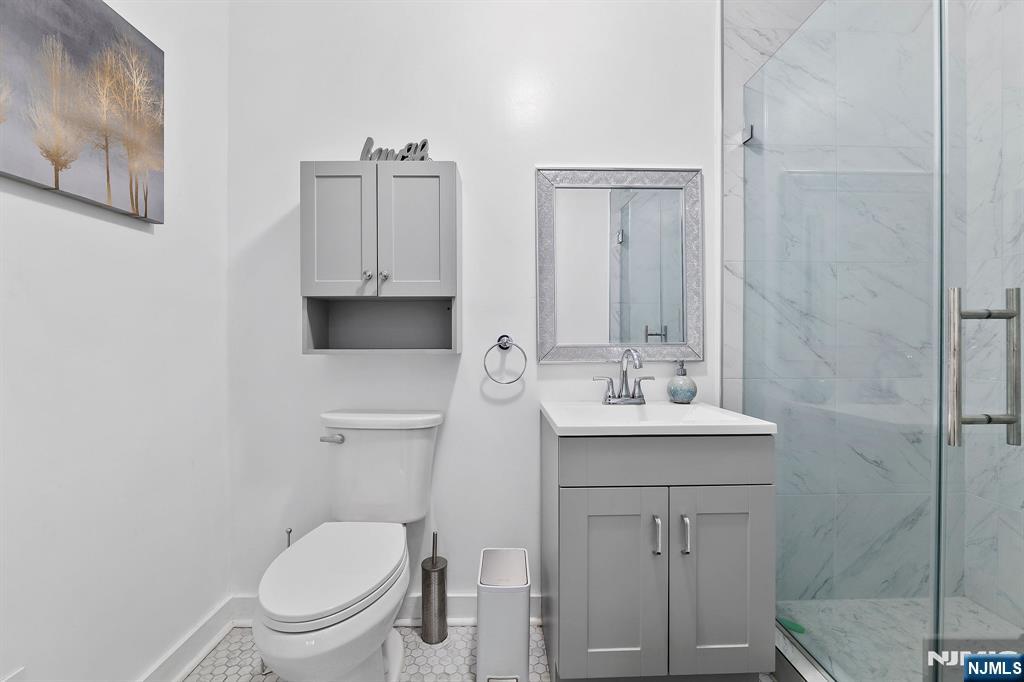 142 Main Avenue, Unit 4A Passaic, NJ 07055 - Photo 23 of 26 a bathroom with a toilet a sink and mirror