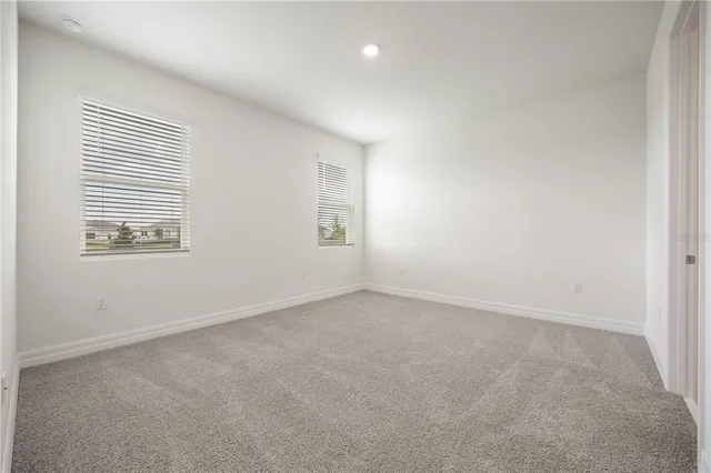an empty room with windows and closet