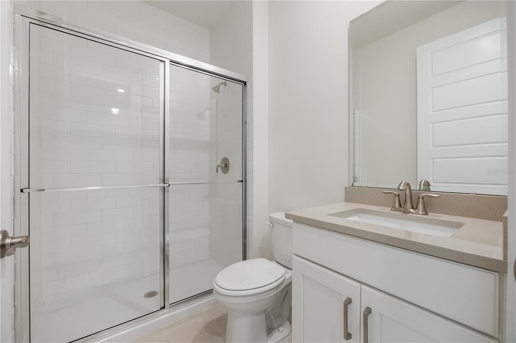 3944 Kennebunk Loop Mount Dora, FL 32757 - Photo 25 of 32 a bathroom with a granite countertop sink toilet and shower