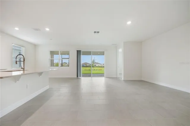 a view of large kitchen with a sink and a refrigerator