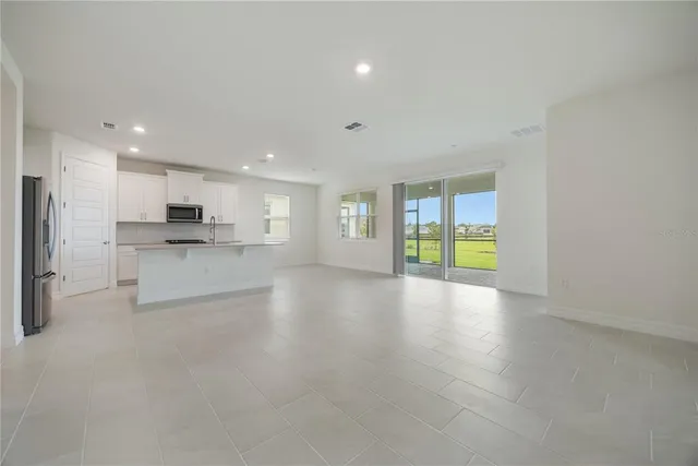 a view of kitchen with stainless steel appliances refrigerator sink and cabinets