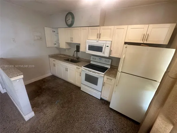 a kitchen with refrigerator a stove a microwave and cabinets