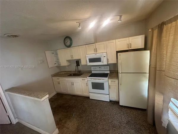 a kitchen with appliances a refrigerator and a stove top oven