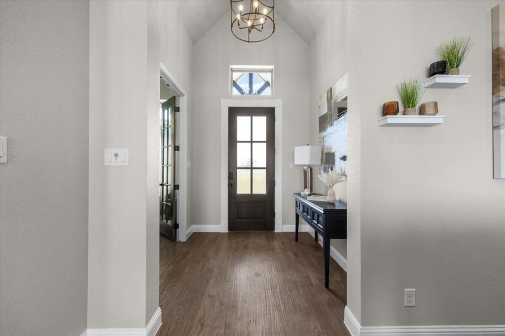 329 Palo Alto Drive Springtown, TX 76082 - Photo 6 of 34 Vaulted entryway featuring a dark wood-paneled door with glass inserts, and a decorative chandelier