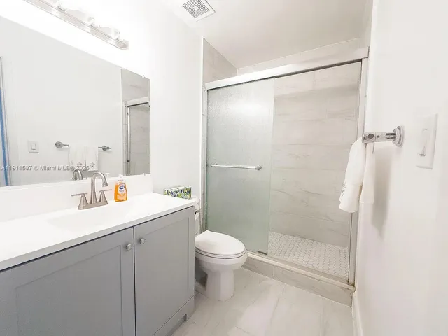 a bathroom with a sink vanity and toilet