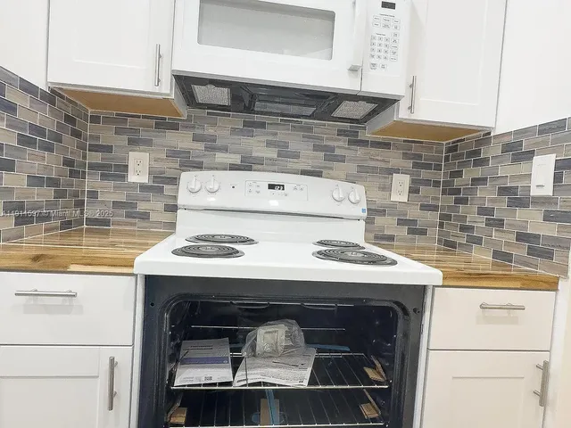 a stove top oven sitting inside of a kitchen