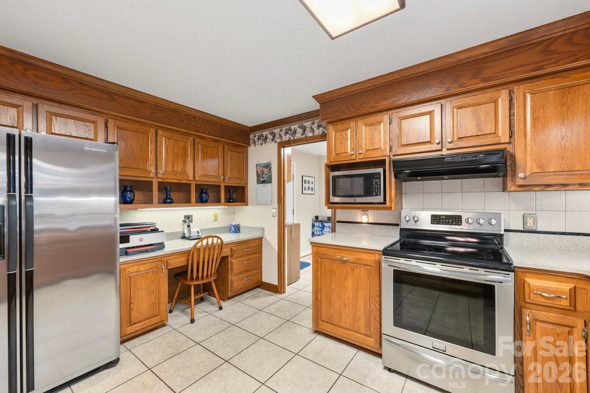 207 Lost Corner Road Morganton, NC 28655 - Photo 19 of 46 a kitchen with stainless steel appliances granite countertop a stove a refrigerator and a stove top oven