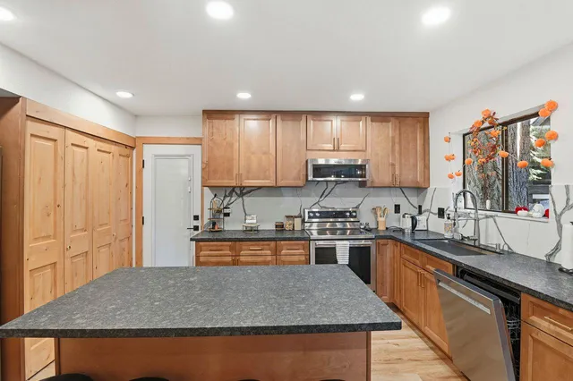 a kitchen with stainless steel appliances granite countertop a sink stove and refrigerator