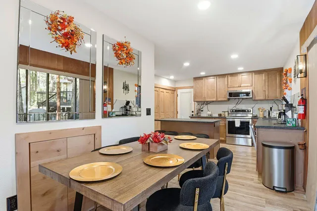 a open dining room with stainless steel appliances a table and chairs