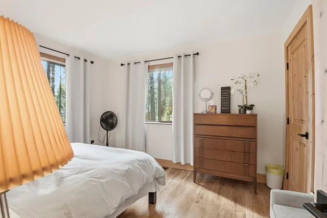 a bedroom with a bed and a lamp next to a window