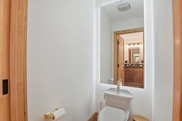 a bathroom with a toilet a sink and a mirror