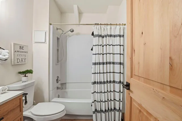 a bathroom with a sink a toilet and shower curtain