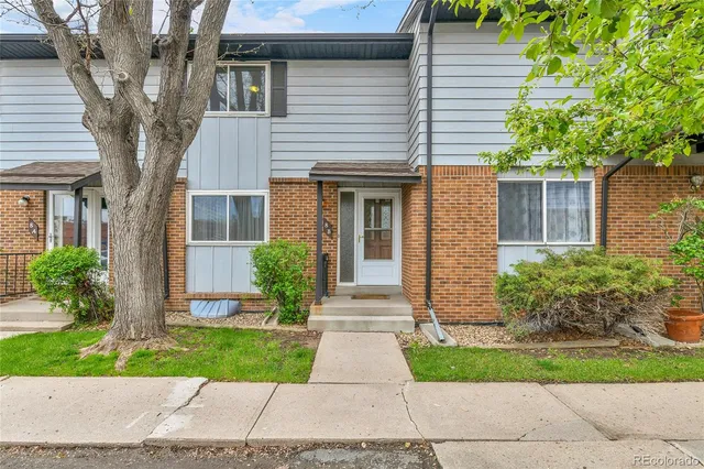 a front view of a house with yard and green space