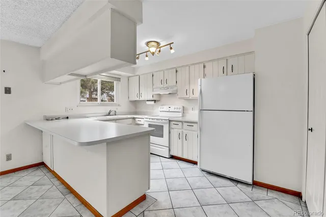a kitchen with white cabinets and white appliances