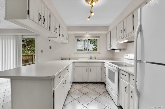 a kitchen with white cabinets and white appliances