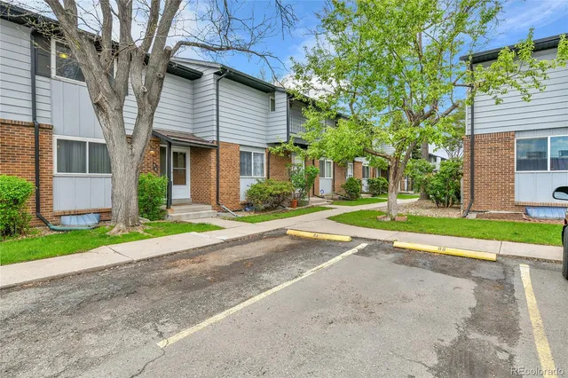 a view of a house with a yard and large tree