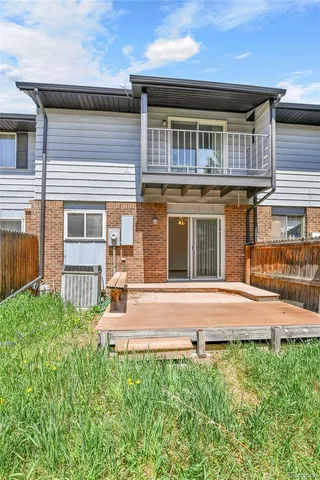 a view of a backyard with brick wall and plants