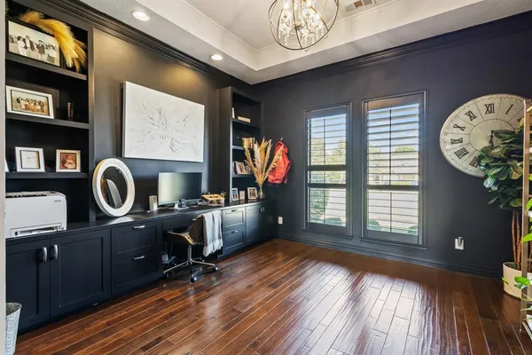 a view of a workspace with furniture and a window