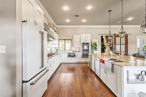 a kitchen with stainless steel appliances a lot of counter space and wooden floors