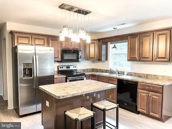 a kitchen with granite countertop a sink stove and refrigerator