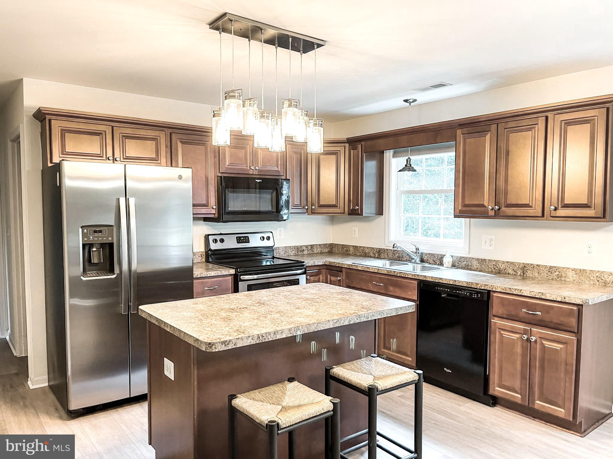 18162 White Tail Way St. Inigoes, MD 20684 - Photo 13 of 29 a kitchen with granite countertop a sink stove and refrigerator