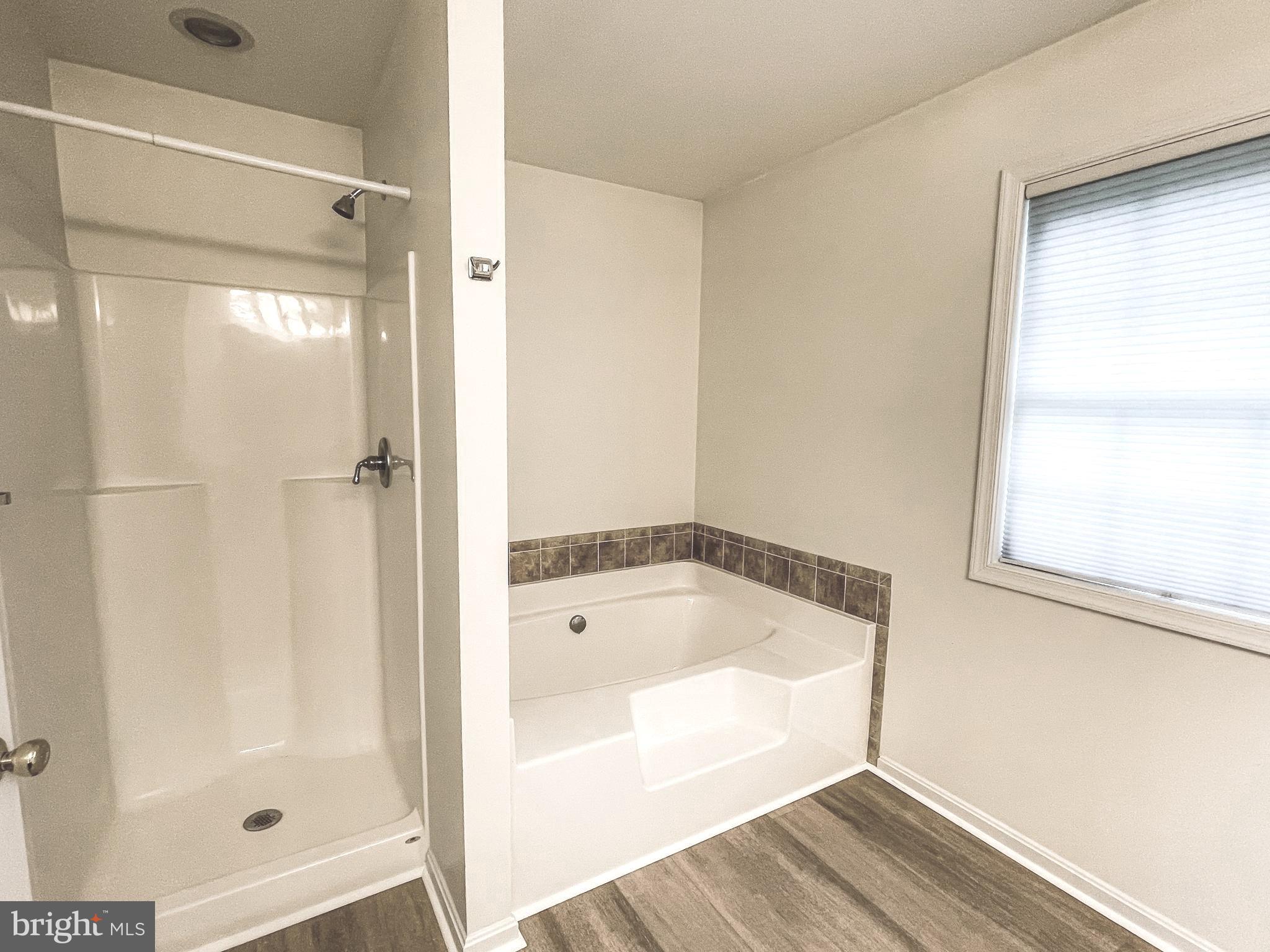 18162 White Tail Way St. Inigoes, MD 20684 - Photo 18 of 29 a bathroom with a tub shower and sink