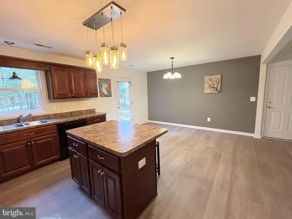 a kitchen with a stove a sink a refrigerator and wooden floor