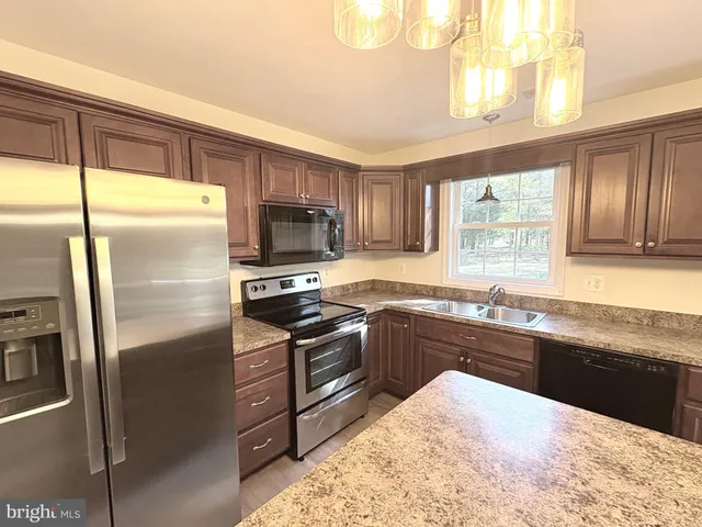 a kitchen with stainless steel appliances granite countertop a stove and a refrigerator