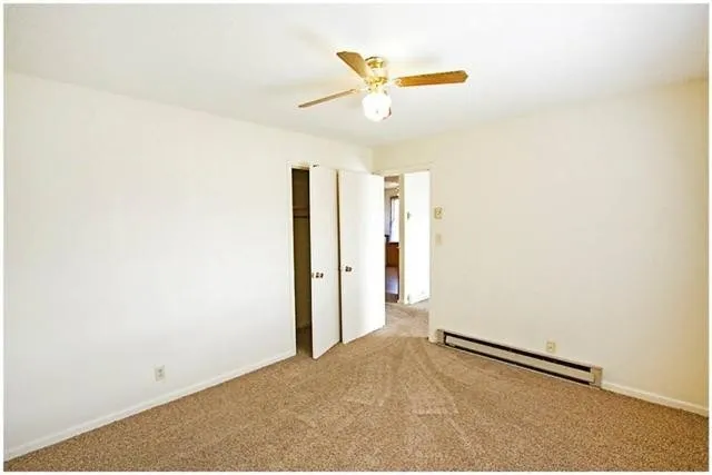 a view of a livingroom with a ceiling fan and wooden floor