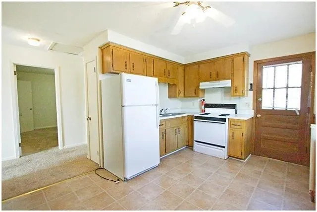 a kitchen with a refrigerator sink and cabinets