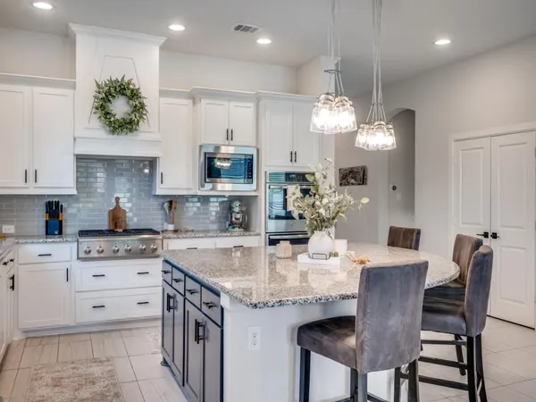 a kitchen with kitchen island granite countertop a sink a center island and cabinets