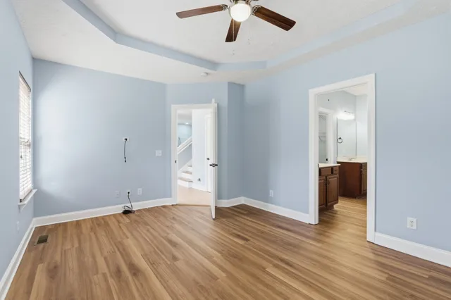 a view of a room with wooden floor and a ceiling fan