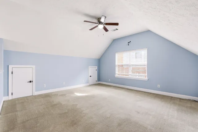 an empty room with closet and windows
