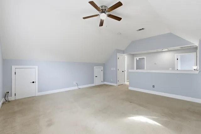 an empty room with closet and a ceiling fan