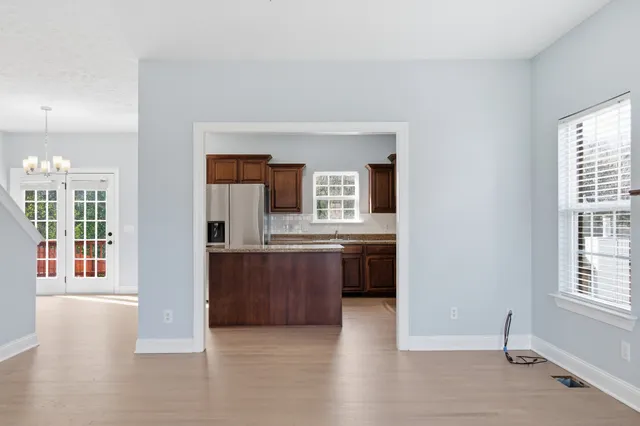 a view of a kitchen and an entryway with wooden floor