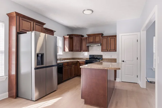 a kitchen with stainless steel appliances granite countertop a refrigerator stove and a sink