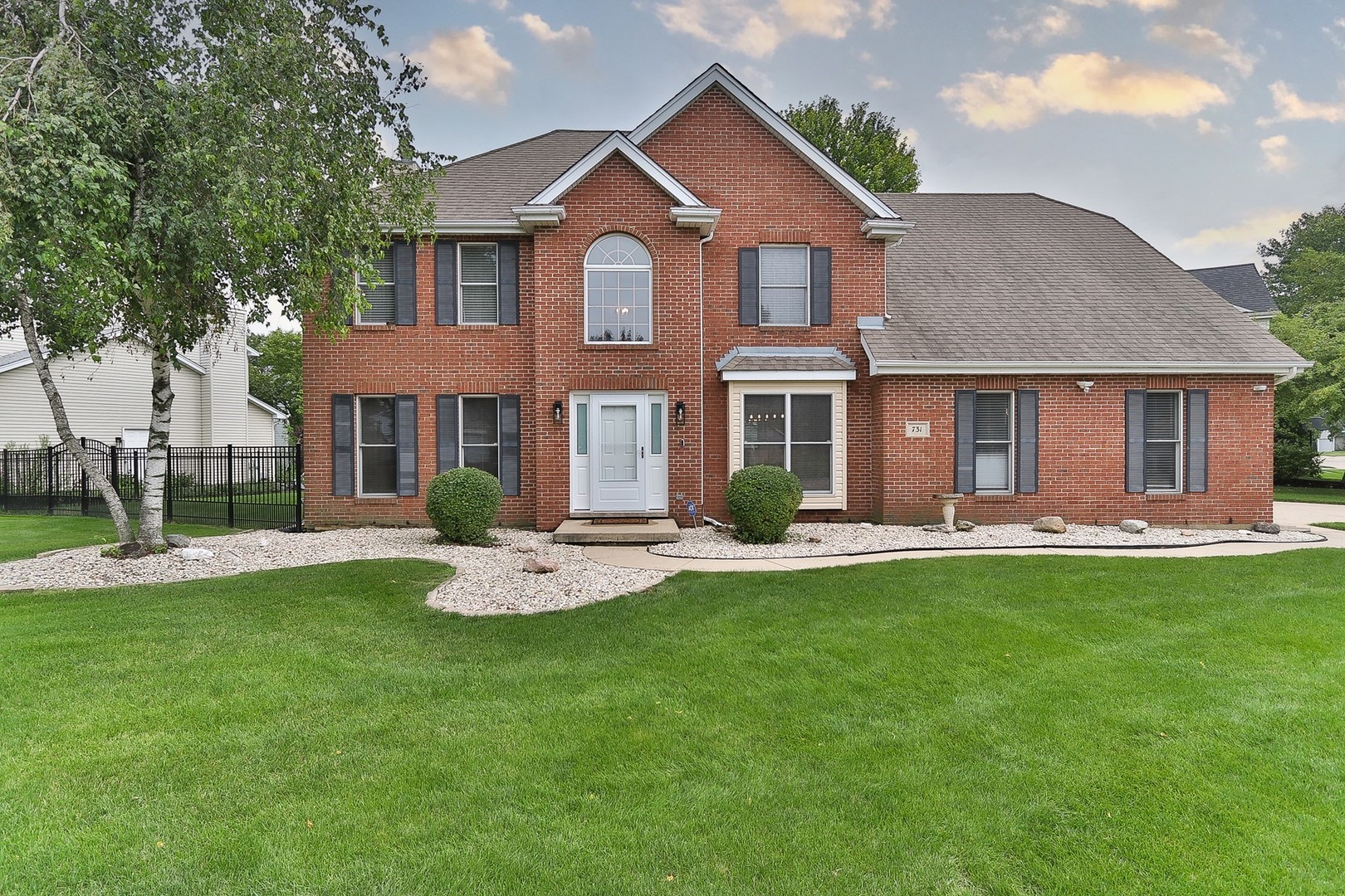 a front view of a house with a garden and patio