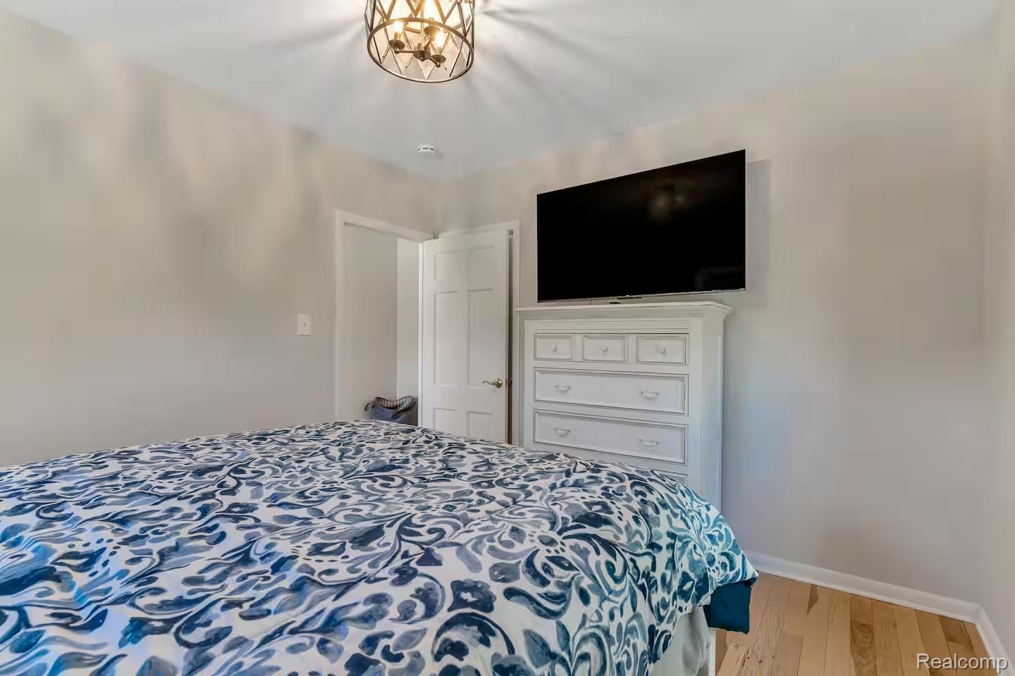 4567 North Seymour Road Flushing, MI 48433 - Photo 29 of 43 Bedroom featuring light wood-finish flooring, light-toned walls, and a multi-paneled interior door