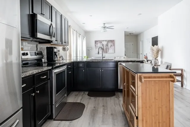a kitchen with stainless steel appliances granite countertop a sink stove and refrigerator