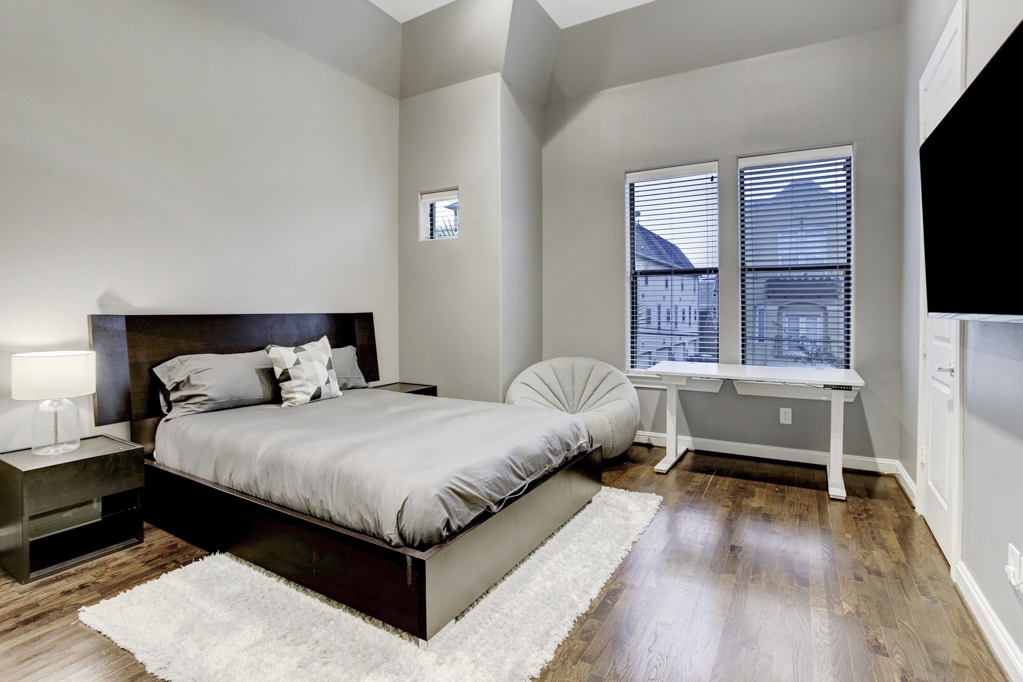 5506 Darling Street Houston, TX 77007 - Photo 16 of 23 Guest Bedroom with queen-sized bed and night stands, wall-mounted TV, walk-in closet and a shared full bath. Notice the 2 large windows, high ceiling and hardwood floor. Unseen are recessed lighting and a ceiling fan.