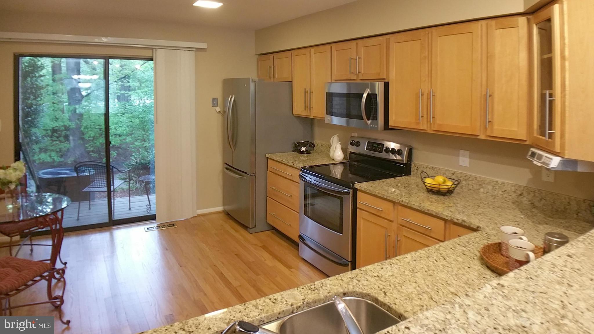 11204 Lagoon Lane Reston, VA 20191 - Photo 5 of 30 a kitchen with stainless steel appliances granite countertop a refrigerator a stove top oven a sink and dishwasher with wooden floor