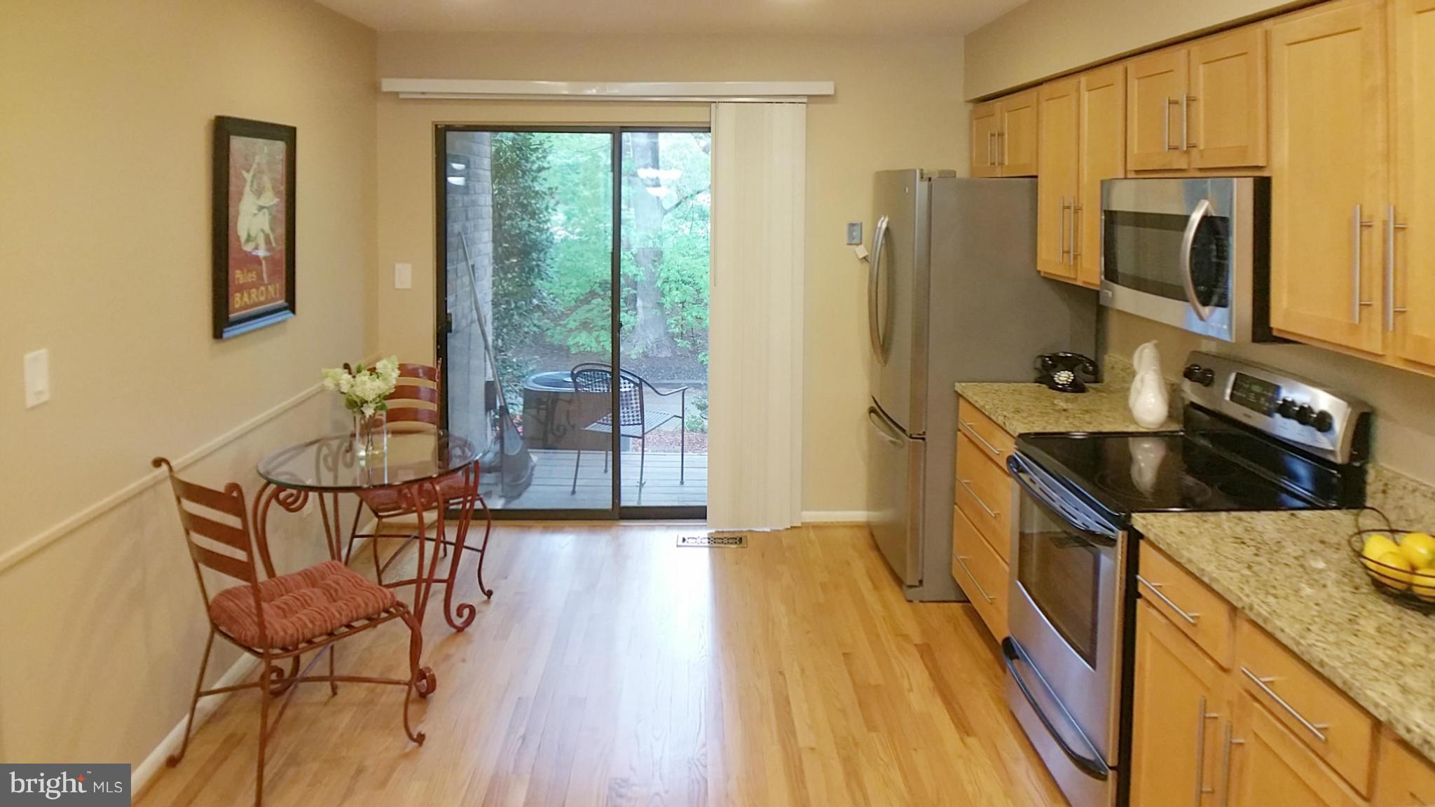 11204 Lagoon Lane Reston, VA 20191 - Photo 6 of 30 a kitchen with stainless steel appliances granite countertop a refrigerator a stove top oven a sink dishwasher and wooden cabinets with wooden floor